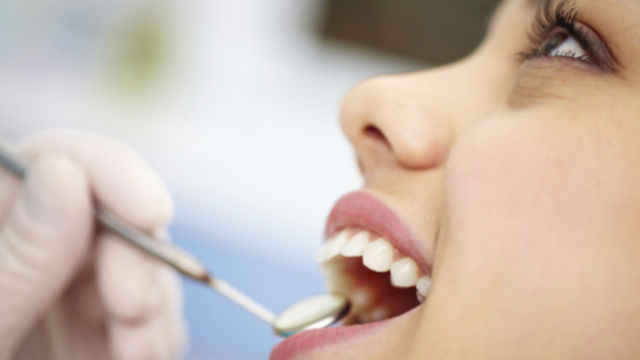 Fille examinant les dents avec une loupe