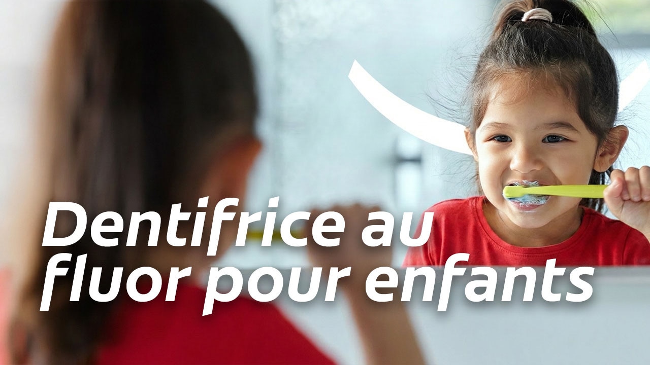Une petite fille se brossant les dents tout en regardant son reflet dans le miroir, avec le texte « Dentifrice au fluor pour enfants ».