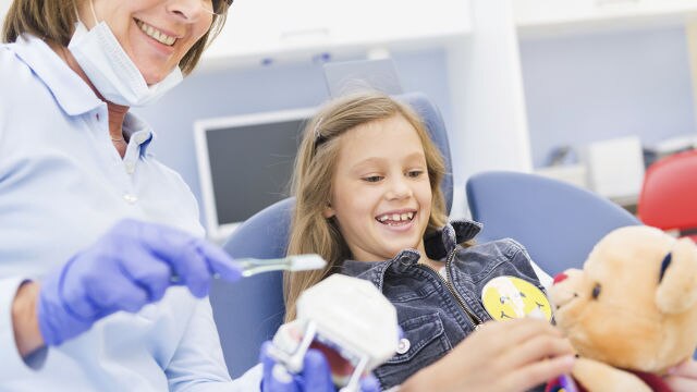 Fillette avec sa peluche chez le dentiste