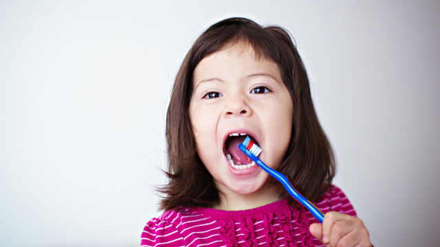 Une petite fille se brossant les dents