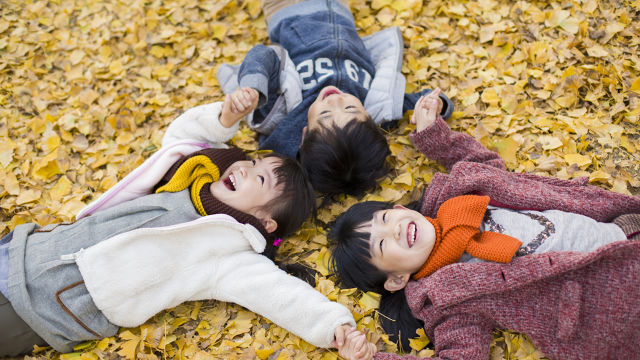 Des enfants jouant dans les feuilles en automne