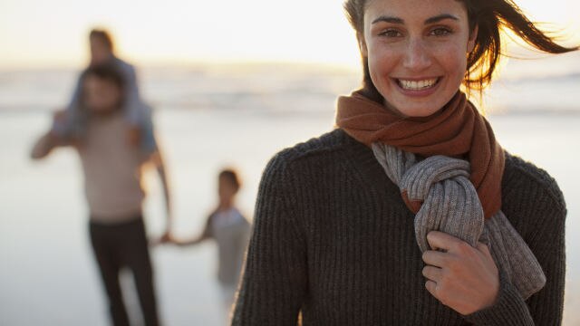 Mère regardant la caméra et la famille derrière