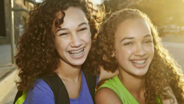 Un pair d'amies souriant et regardant la caméra