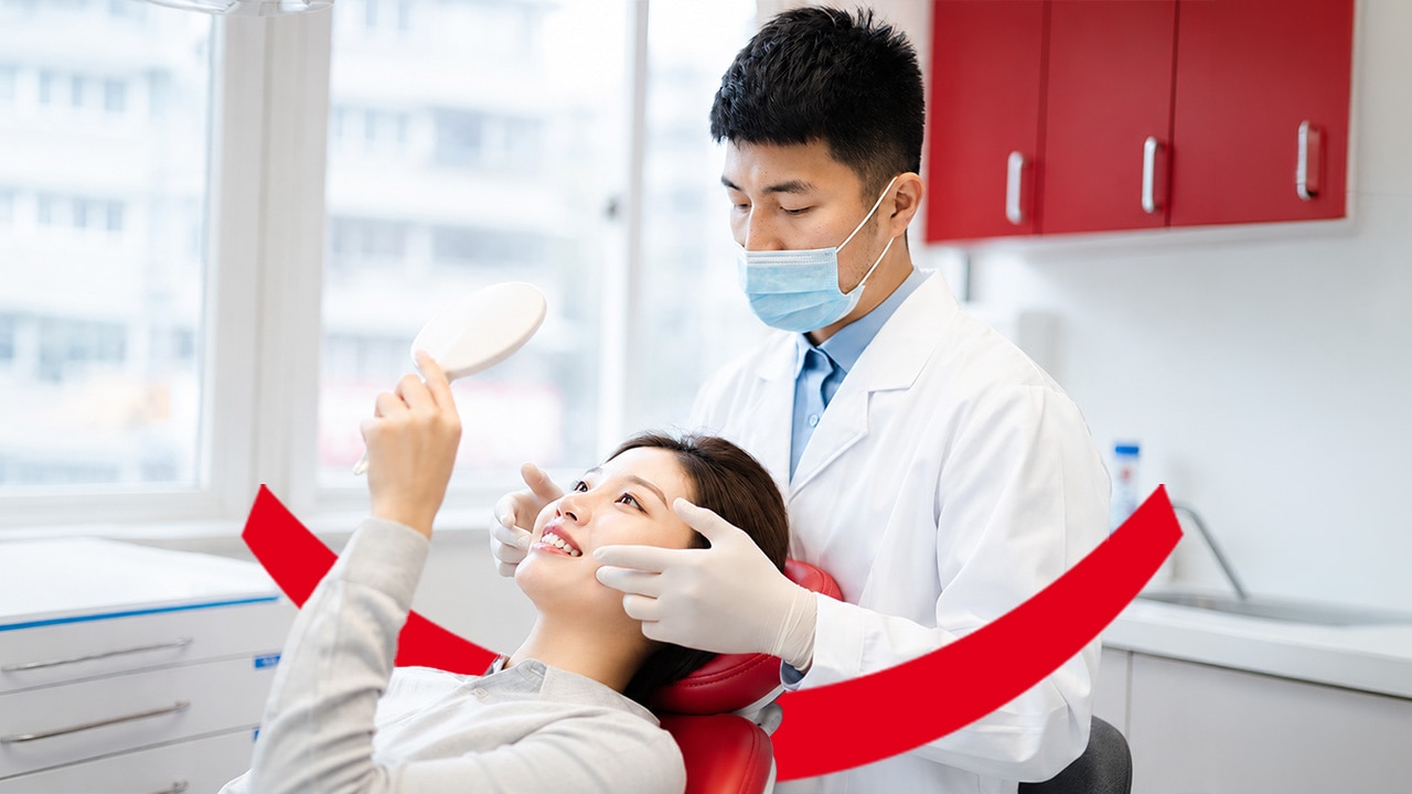 Une femme se regardant dans un miroir pendant qu'un dentiste examine ses dents, accompagné du texte « Excès de Fluor - Un excès de fluor est-il possible ? Informez-vous ».